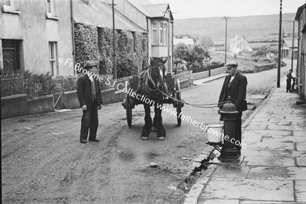 MAN LEADING HORSE AND CART UP STREET